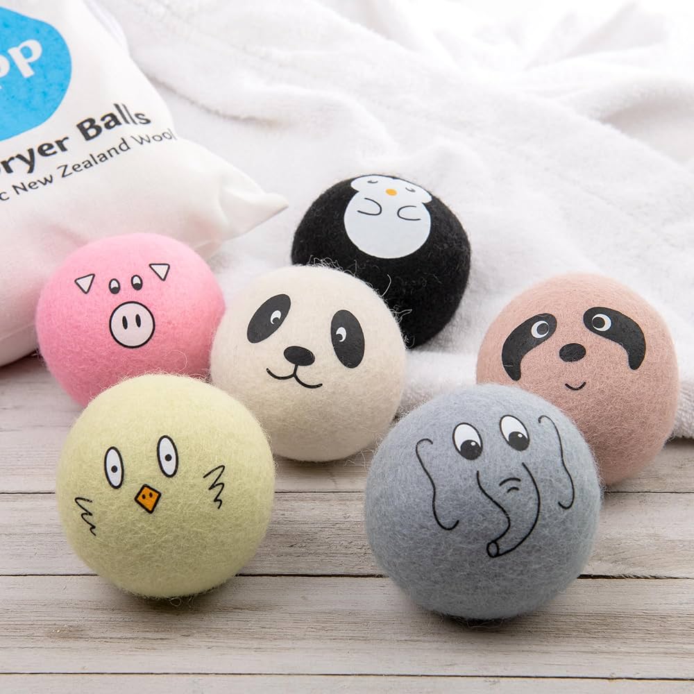 Six wool dryer balls with cute animal designs on a white background.