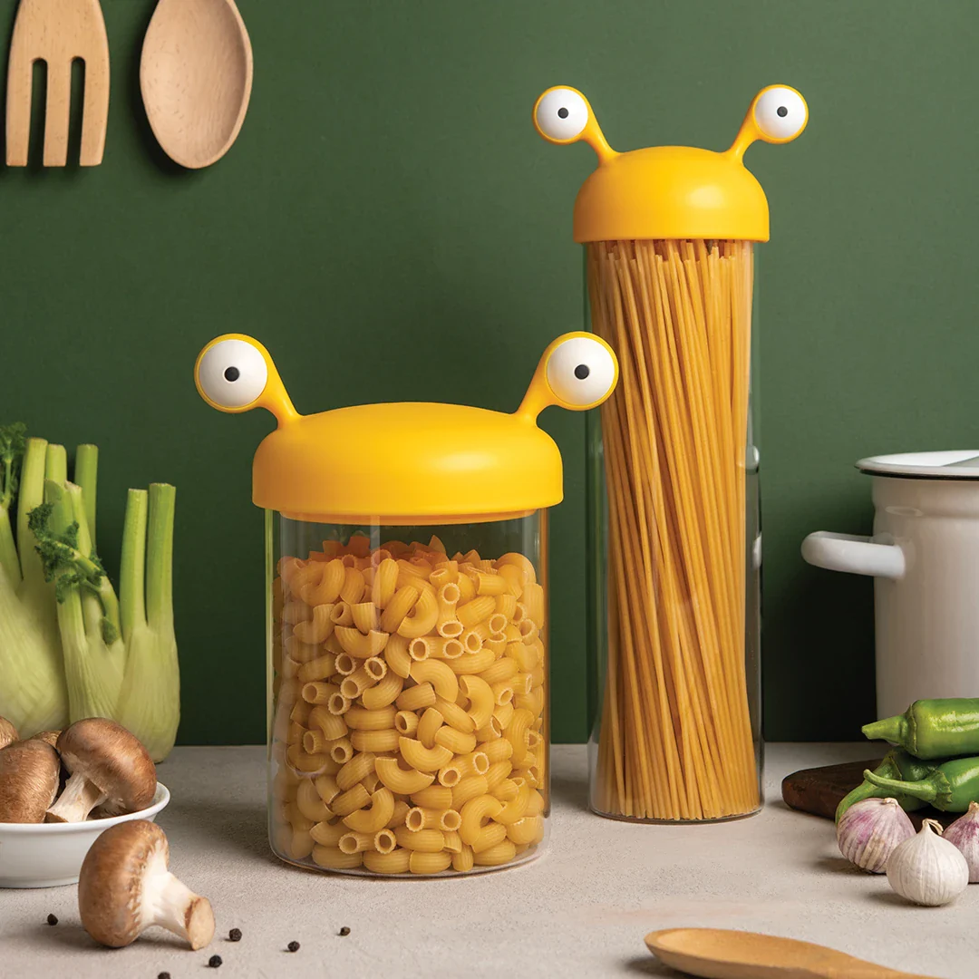 An image showing the OTOTO Noodle Monster Spaghetti Container, a cute and quirky glass pasta storage container with googly eyes.