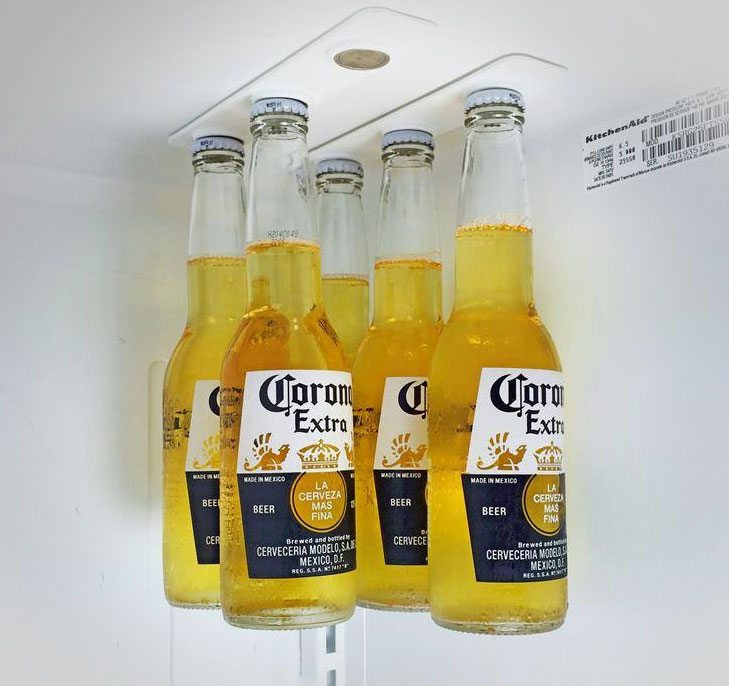 The BottleLoft by Strong like Bull Magnets hanging on a refrigerator ceiling, holding six bottles securely with magnetic strips.